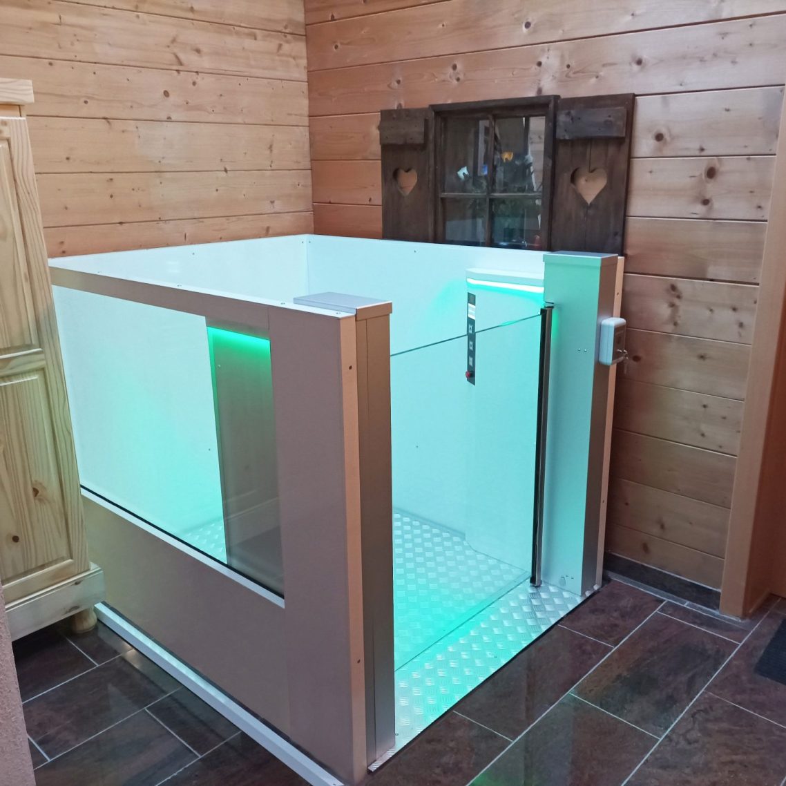 Moderne Hublifte aus Glas mit sanfter Beleuchtung in einem rustikalen Raum. Moderne Hublifte aus Glas mit sanfter Beleuchtung in einem rustikalen Raum.